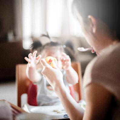 Mum feeding baby in highchair