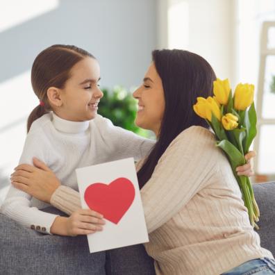 picture of a mum giving child a card and some flowers