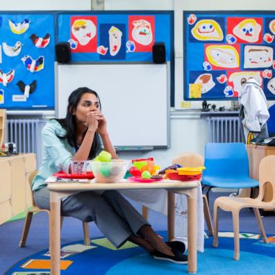 picture of a nursery teacher sat in a classroom