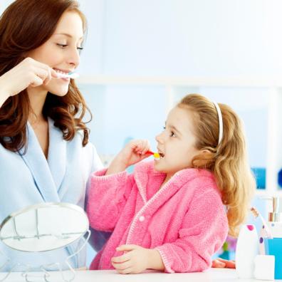 picture of a parent teaching a child how to brush their teeth