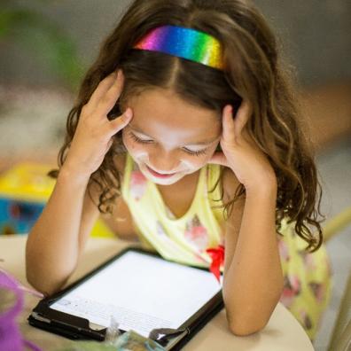 Picture of a happy child watching an ipad