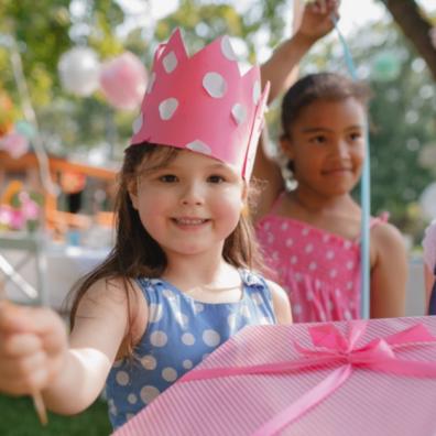 picture of a girl at a birthday party with a party hat and present