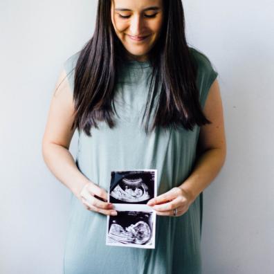 picture of a pregnant woman holding a scan photo