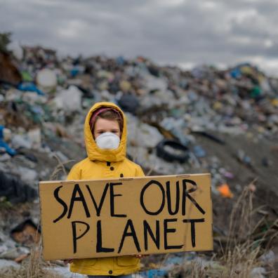 picture of a child at a rubbish dump holiday a sign saying save our planet