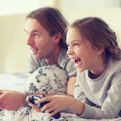 Picture of a child playing video games with her dad